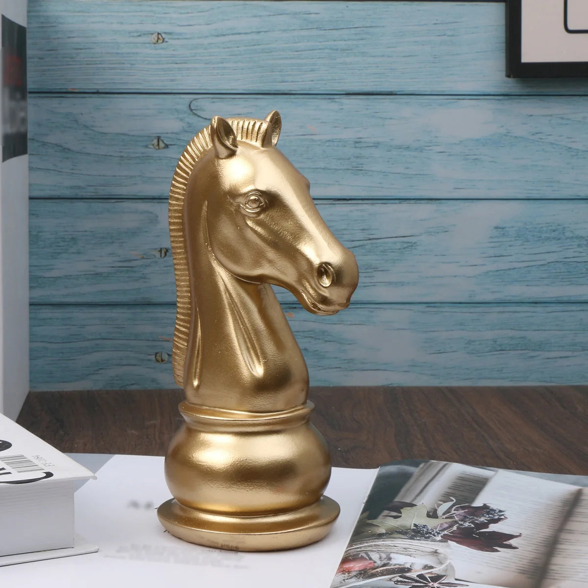 Gold horse-shaped chess piece on a wooden surface with a blue wooden panel background