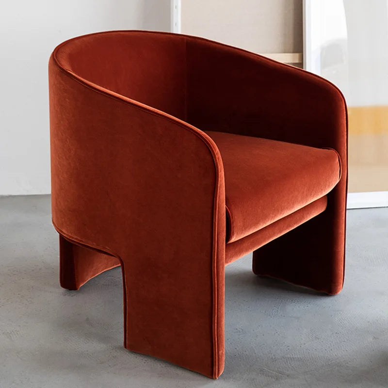 Brown velvet armchair on a gray floor with a neutral background