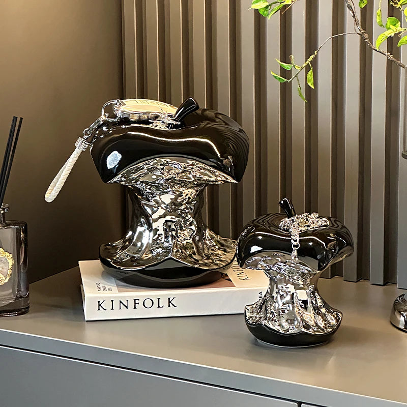 Decorative black and silver lampshades on a surface with a book titled &
