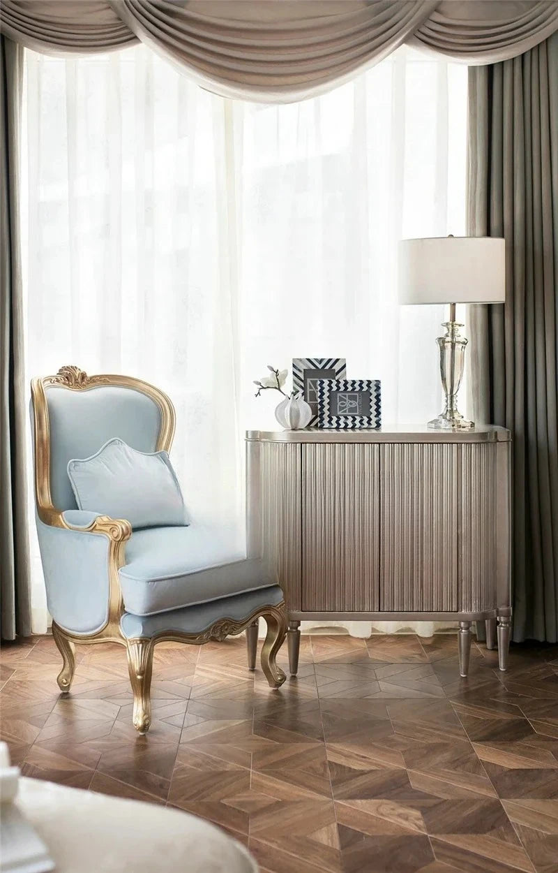 Luxurious interior with a light blue armchair, wooden side table, and lamp.