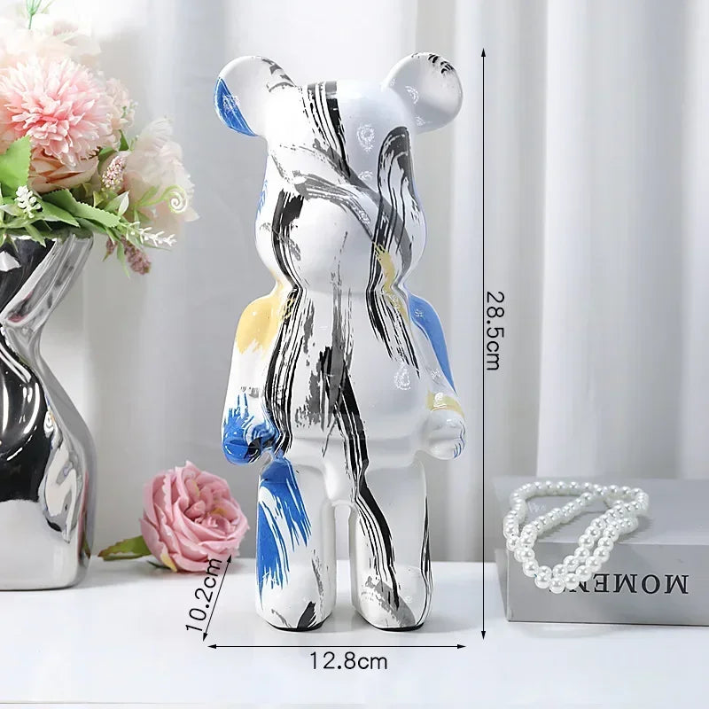 Decorative glass bear figure with measurements on a white surface with flowers and jewelry.