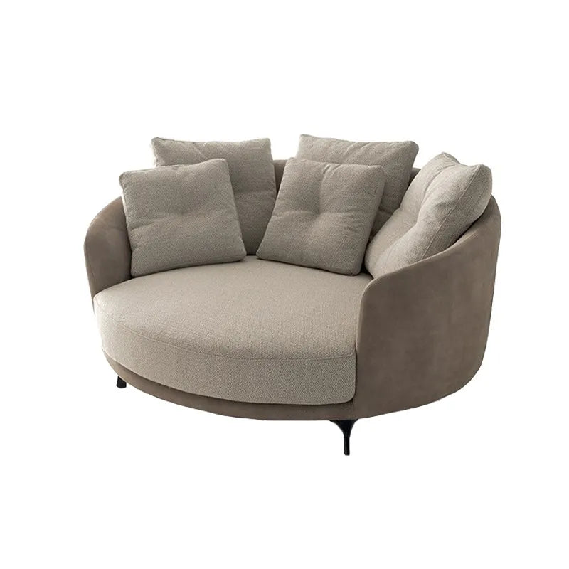 Round beige sofa with cushions on a white background