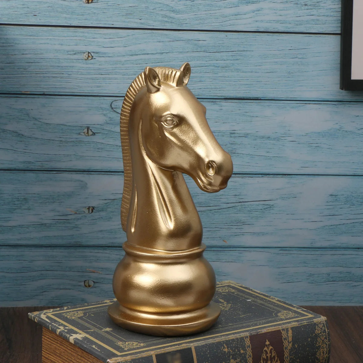Gold horse head sculpture on a book with a blue wooden background