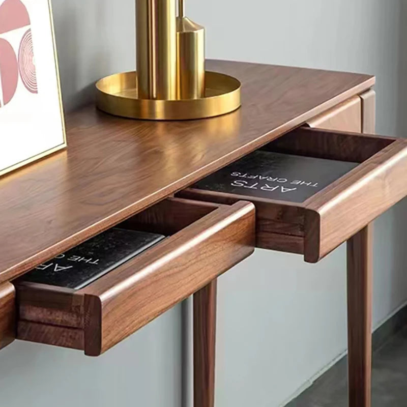 Wooden desk with open drawers and a gold lamp on top