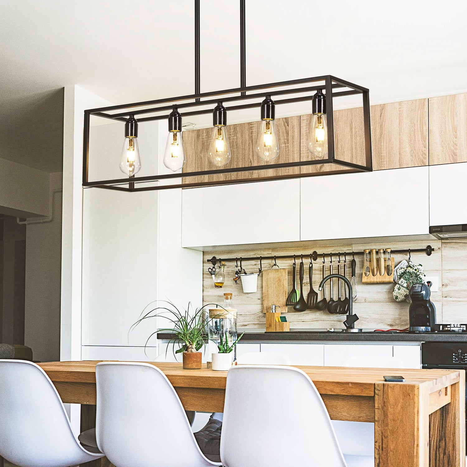 Modern kitchen with wooden dining table, white chairs, and pendant light fixture.