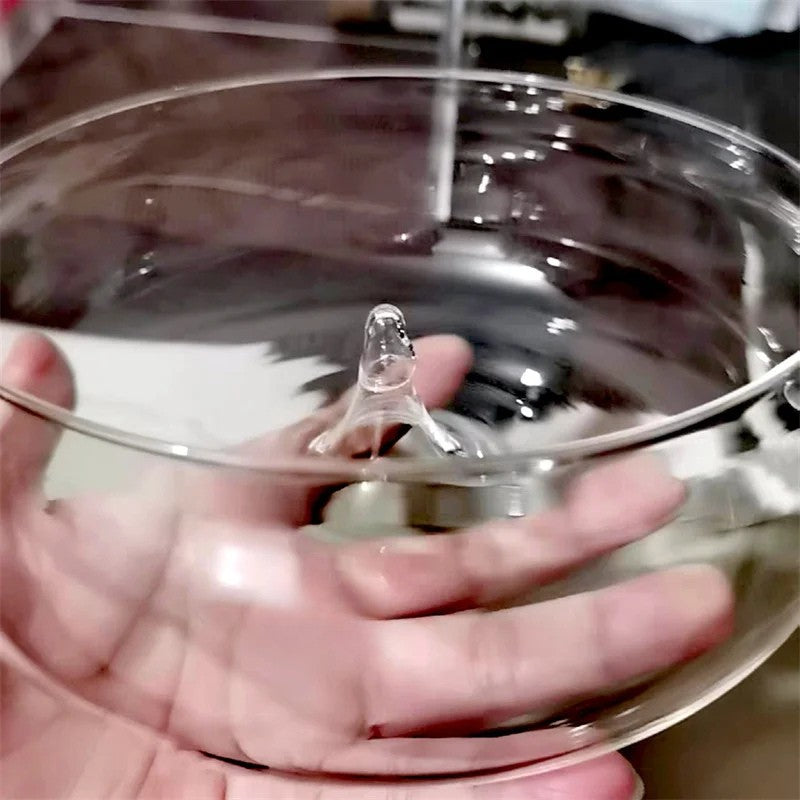 Clear glass lid held by a hand with a blurred background