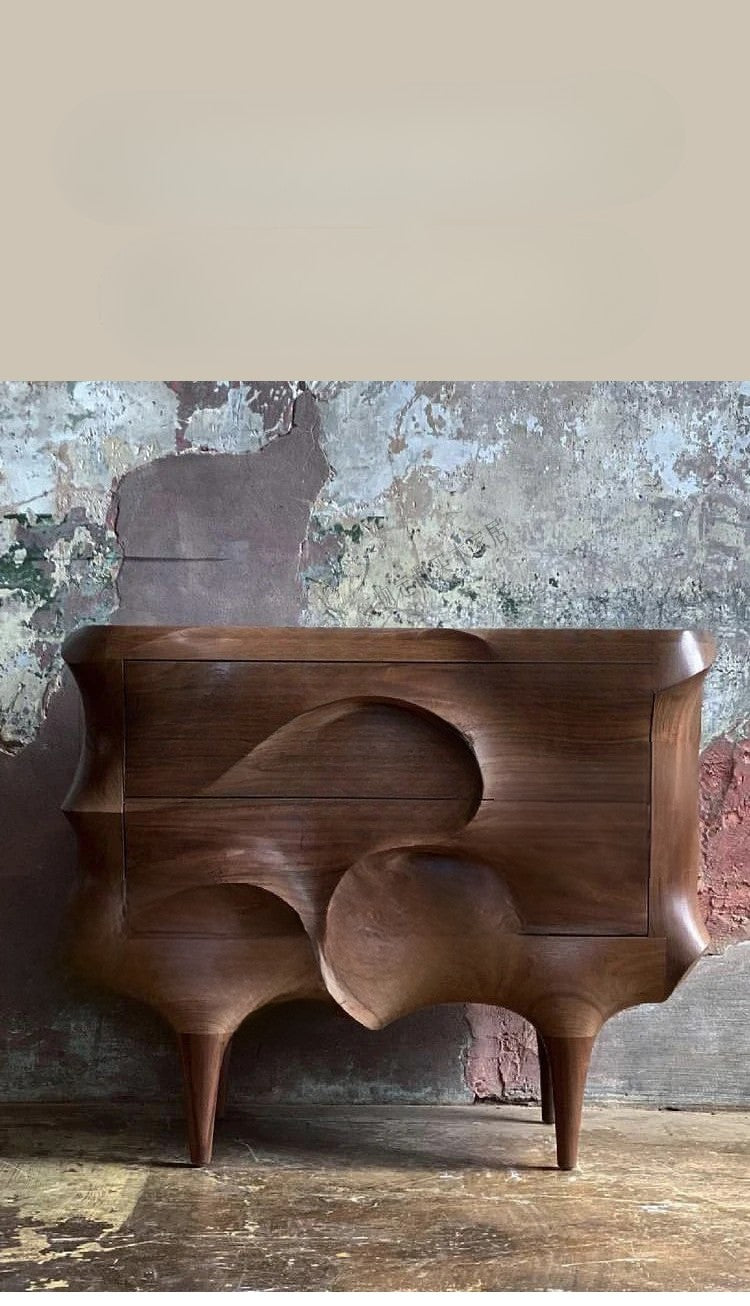 Wooden console table with abstract design against a textured wall.