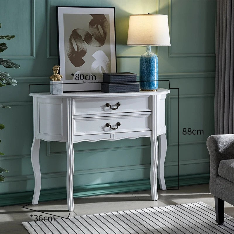 White console table with decorative items against a green wall