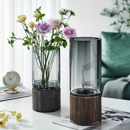 Transparent glass vase with wooden base for Scandinavian-inspired homes.