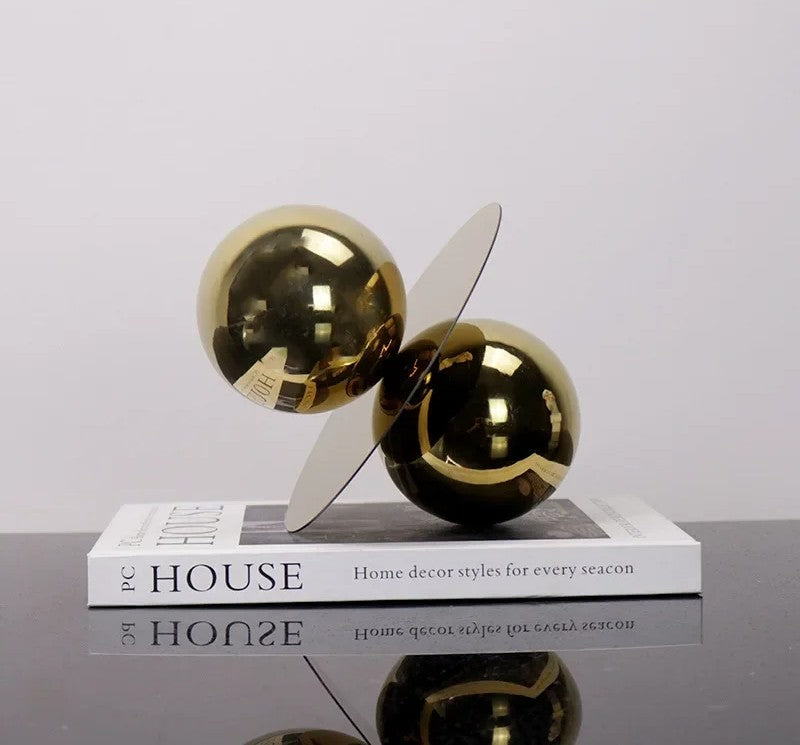Gold spherical sculpture on a book titled &