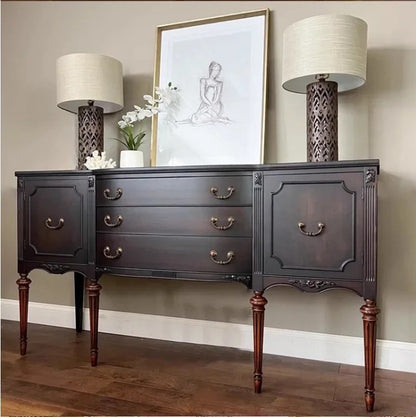 Dark wood sideboard with lamps and artwork in a room setting