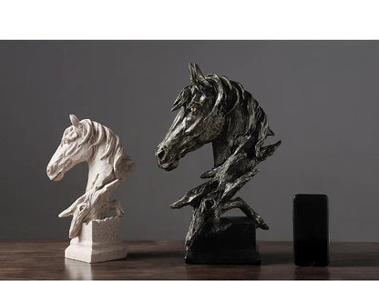 Two horse head sculptures on a dark surface with a gray background