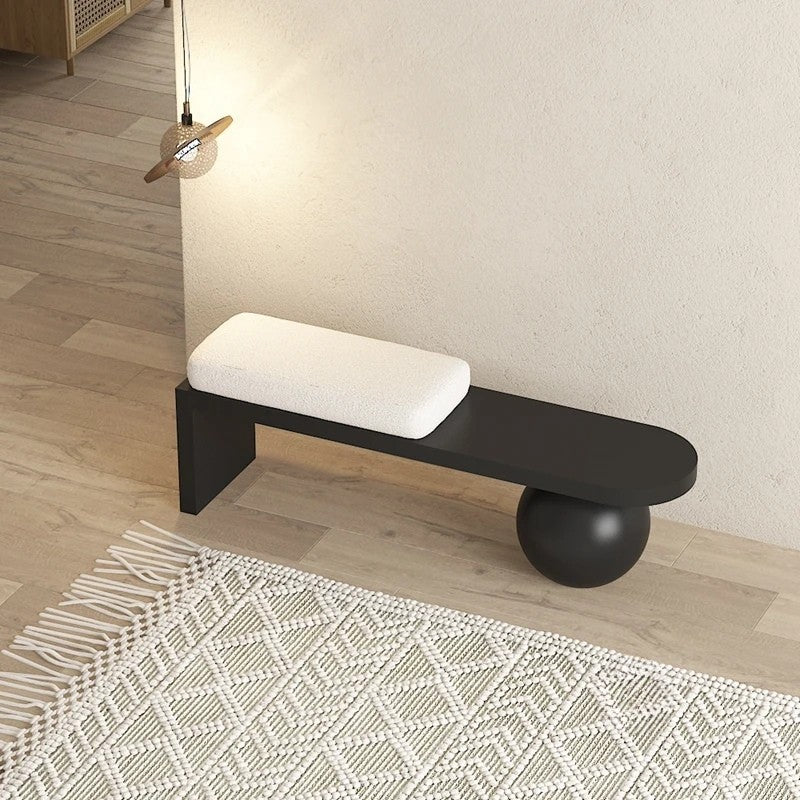Modern black bench with white cushion on a wooden floor