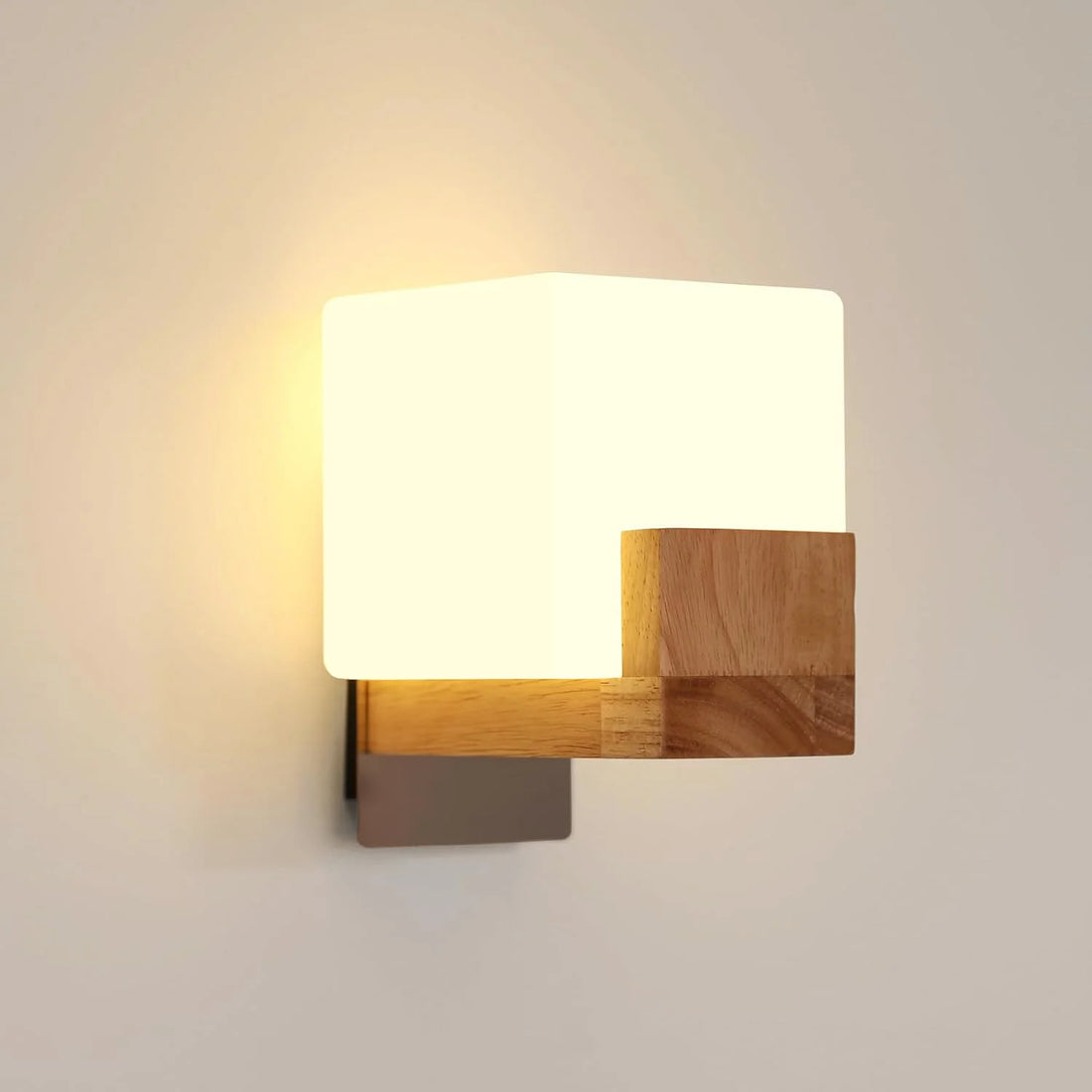Wall-mounted light fixture with wooden base and white shade on a plain wall.
