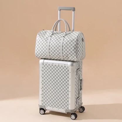 Checkered patterned suitcase and duffel bag on a beige background