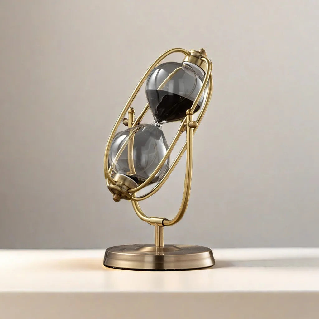 Decorative hourglass with gold frame and glass bulbs on a neutral background
