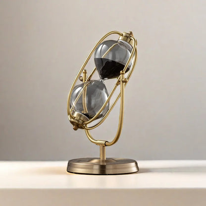 Decorative hourglass with gold frame and glass bulbs on a neutral background