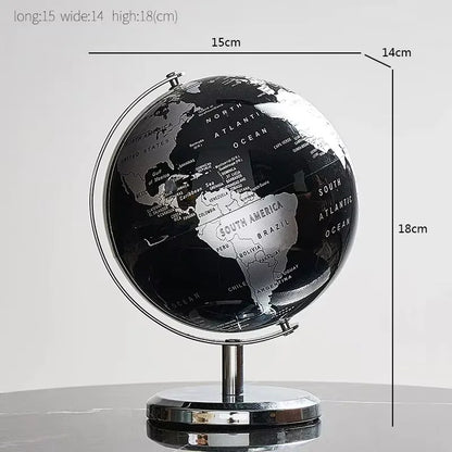 Black and silver world globe with measurements on a light gray background