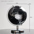 Black and silver world globe with measurements on a light gray background