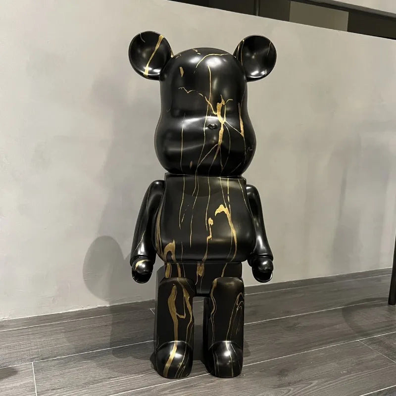 Black and gold marbled bear-like sculpture on a wooden floor.