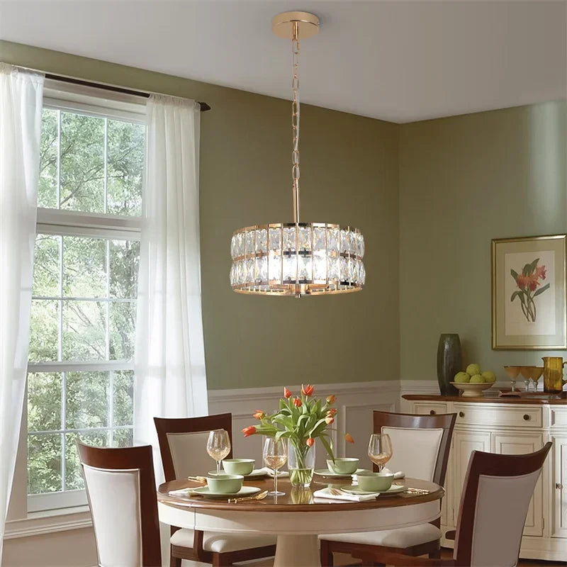 Dining room with a crystal chandelier, table set for dinner, and window view.