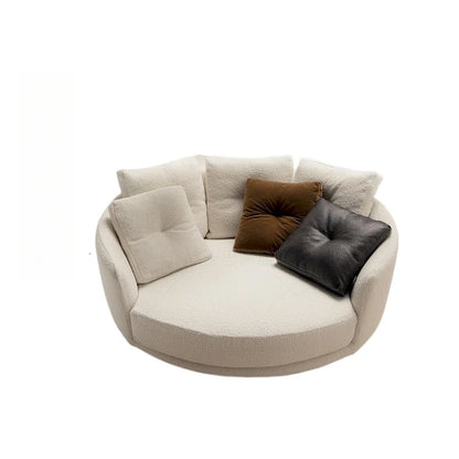 Round beige sofa with decorative cushions on a white background