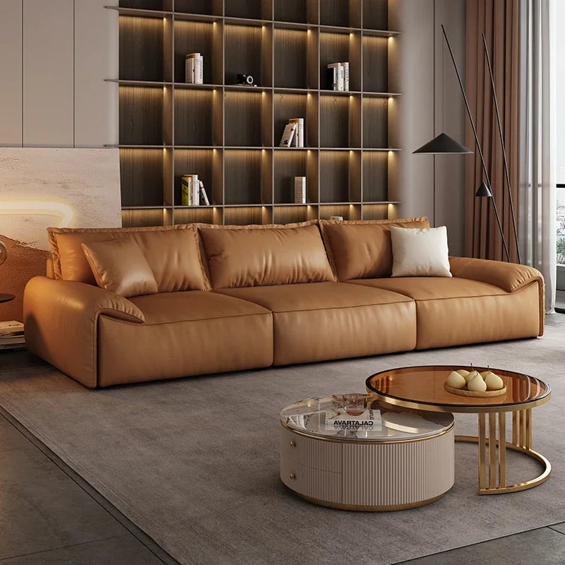 Modern living room with a brown leather sofa, coffee table, and decorative items.