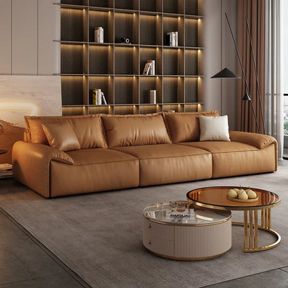 Modern living room with a brown leather sofa, coffee table, and decorative items.