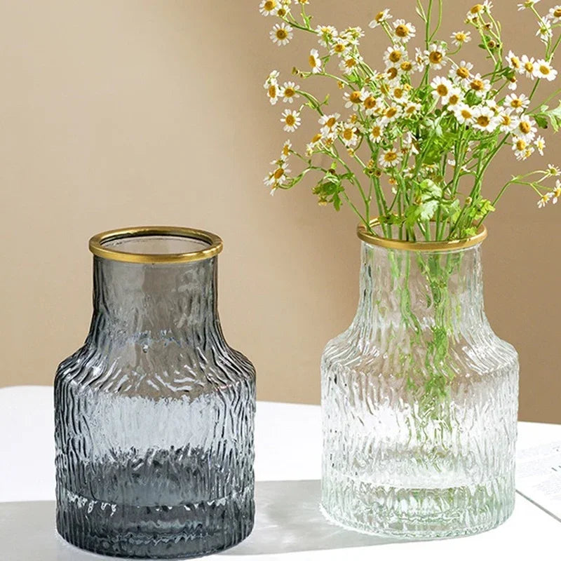 Two glass vases with textured design, one gray and one clear, on a neutral background.