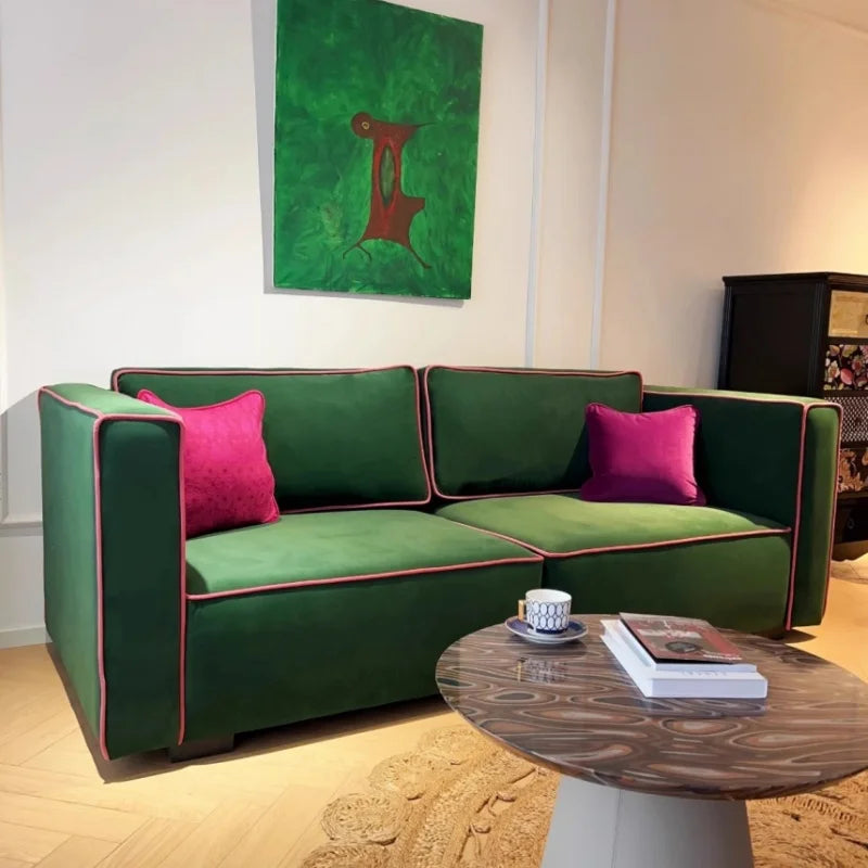 Green sofa with pink cushions in a living room setting