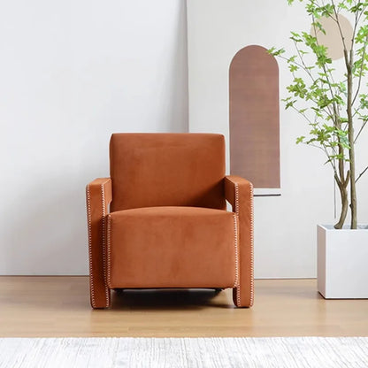 Brown armchair in a room with a plant and wall art