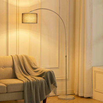 Floor lamp in a living room with a beige sofa and striped wallpaper.