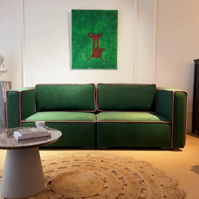 Green sofa in a living room with a abstract painting on the wall.