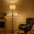 Living room with a green armchair, floor lamp, and fireplace.