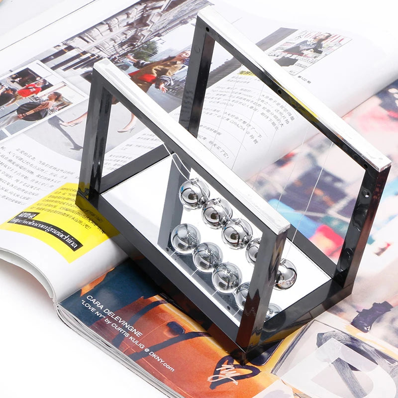Glass weights on a metal stand on top of an open magazine