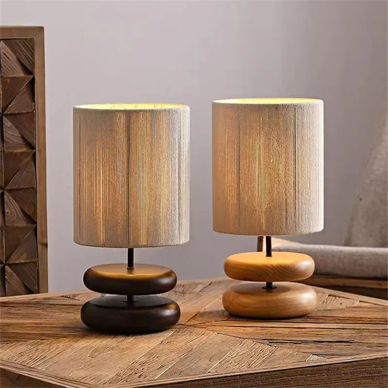 Two wooden table lamps with striped lampshades on a wooden surface.