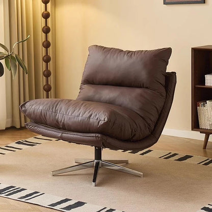 Brown leather armchair in a living room setting with a rug and bookshelf.