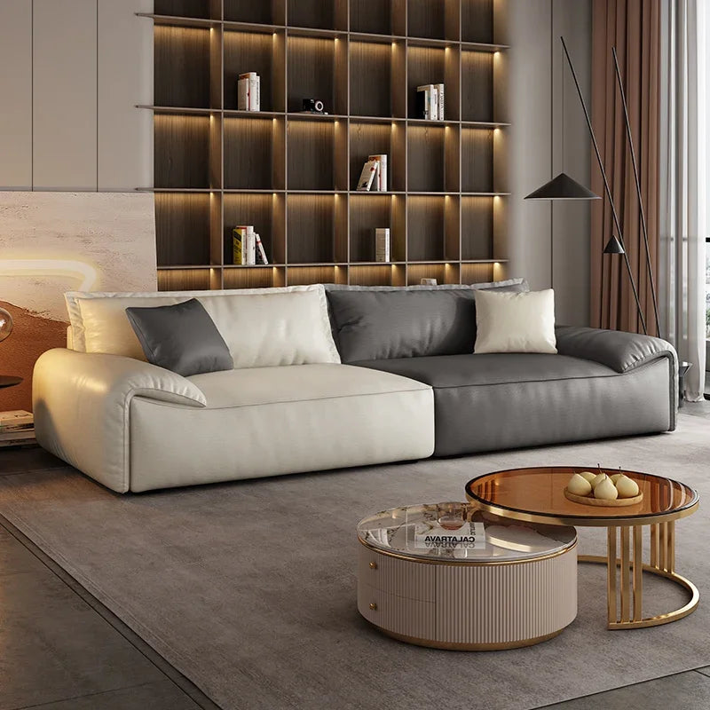 Modern living room with a sectional sofa, coffee tables, and a bookshelf.