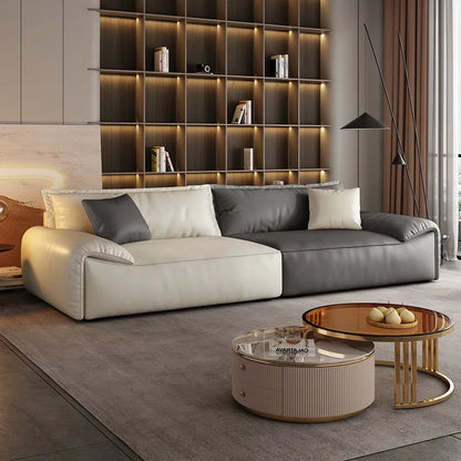 Modern living room with a sectional sofa, coffee tables, and a bookshelf.