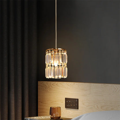 Decorative pendant light hanging above a bed in a bedroom setting.