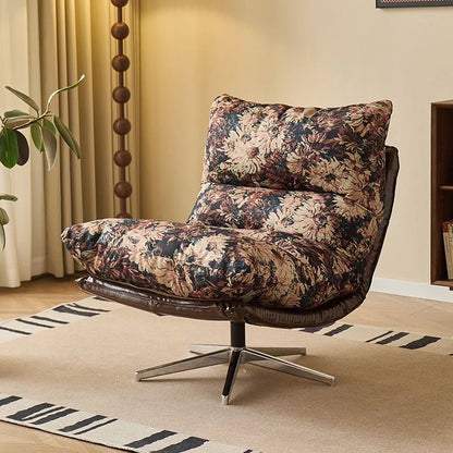Floral-patterned armchair in a living room setting with a rug and plant.