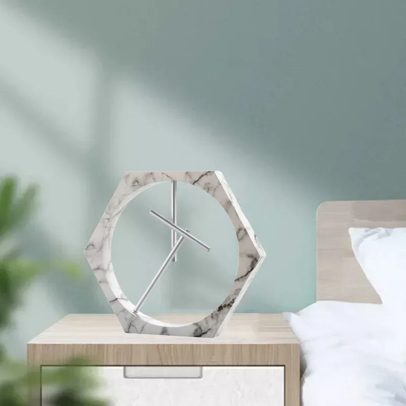 Marble-patterned clock on a nightstand with a blurred bedroom background