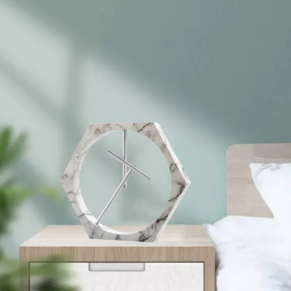 Marble-patterned clock on a nightstand with a blurred bedroom background