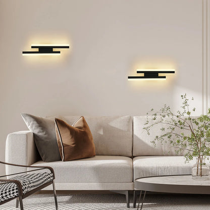 Modern living room with a beige sectional sofa, decorative pillows, and wall lights.