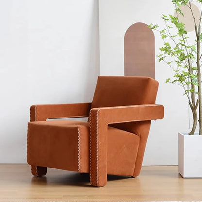 Brown armchair in a room with a white wall and a plant.