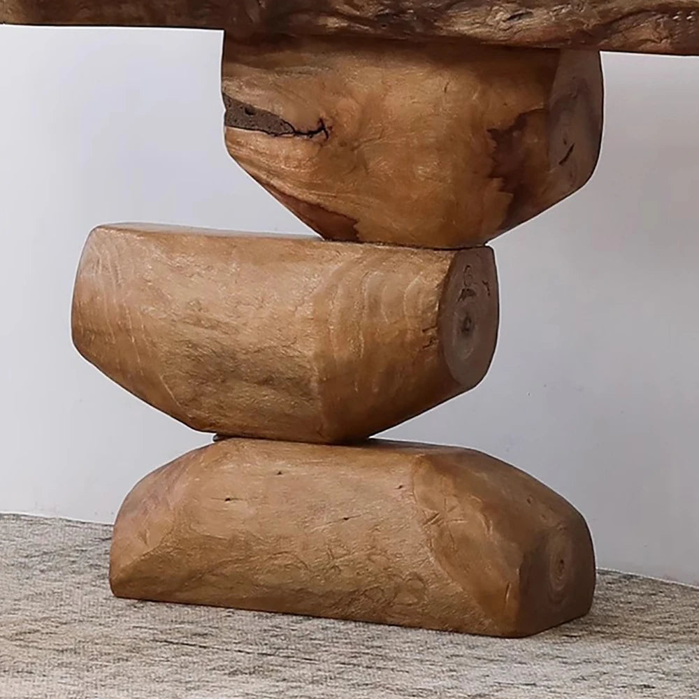 Wooden sculpture of stacked logs on a neutral background