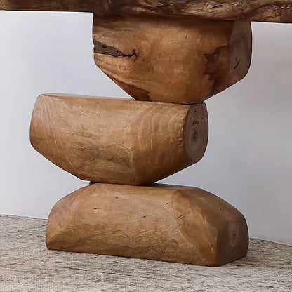 Wooden sculpture of stacked logs on a neutral background