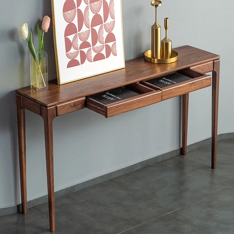 Wooden console table with drawers against a gray wall, featuring decorative items.
