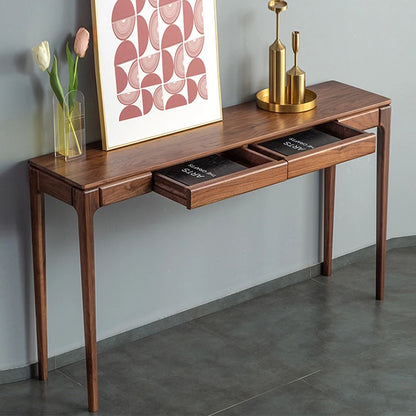 Wooden console table with drawers against a gray wall, featuring decorative items.