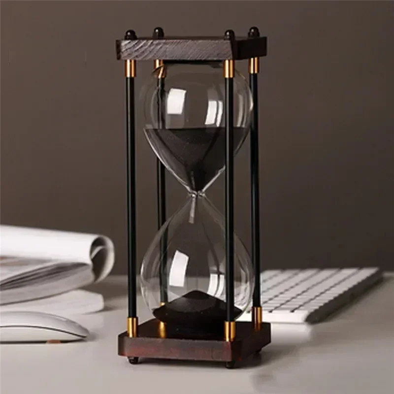 Hourglass on a desk with a computer keyboard and mouse in the background